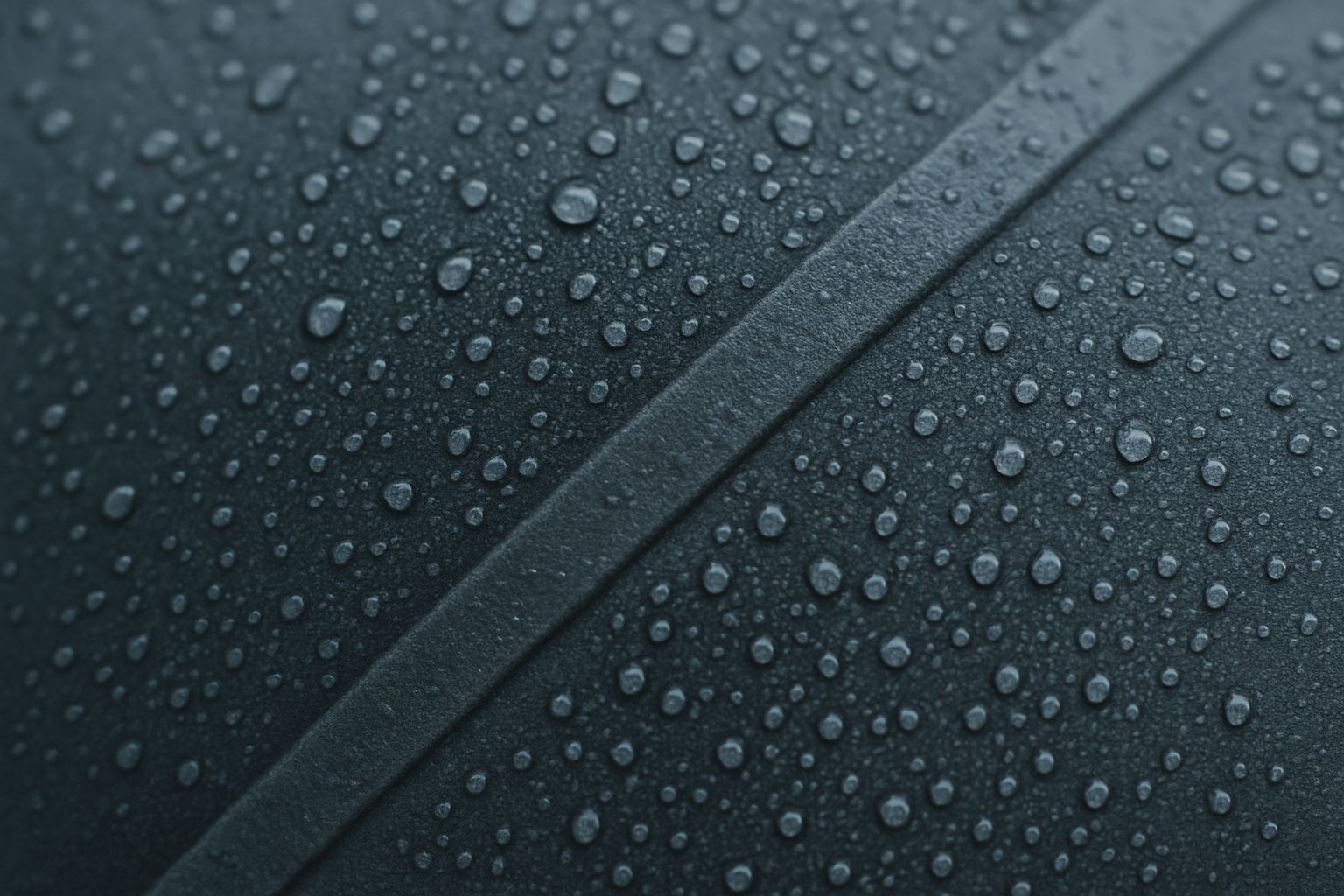 Condensation beading on cold neoprene. A closed surface, and water with nowhere to go.